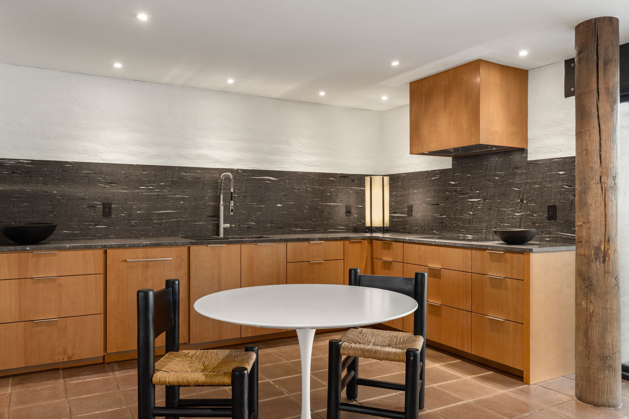 The Ramada House — kitchen with stone backsplash and timber column